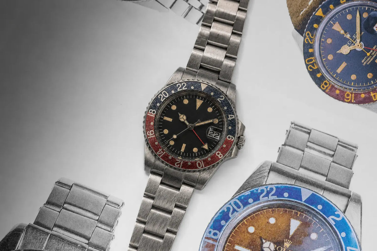 39.5mm vintage red-blue GMT automatic watch with an aged black dial and stainless-steel bracelet displayed over classic GMT watch illustrations.