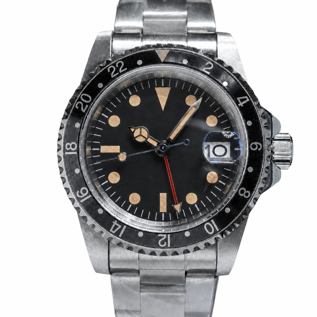 Close-up of a 40mm aged black-bezel GMT watch with a matte-black no-logo dial and warm markers