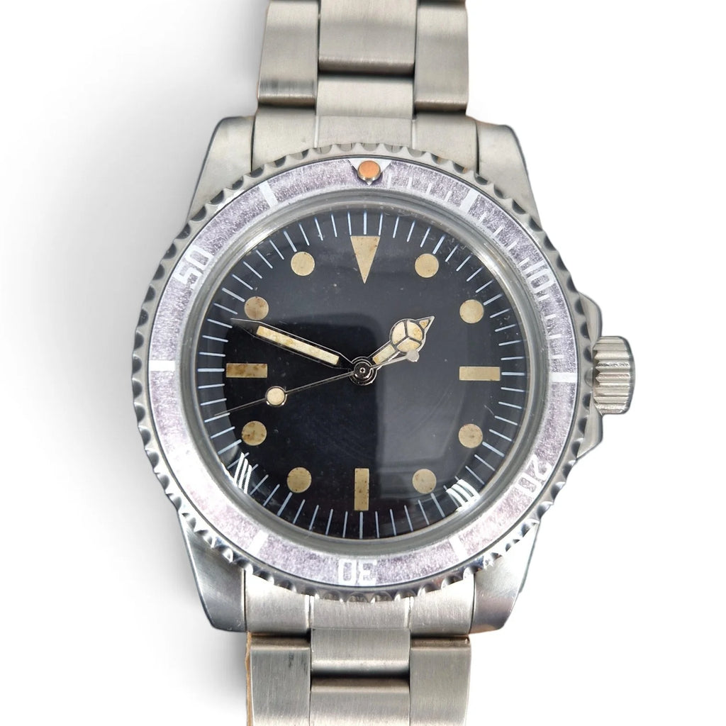 Close-up of the aged black dial, warm vintage lume and faded ghost bezel