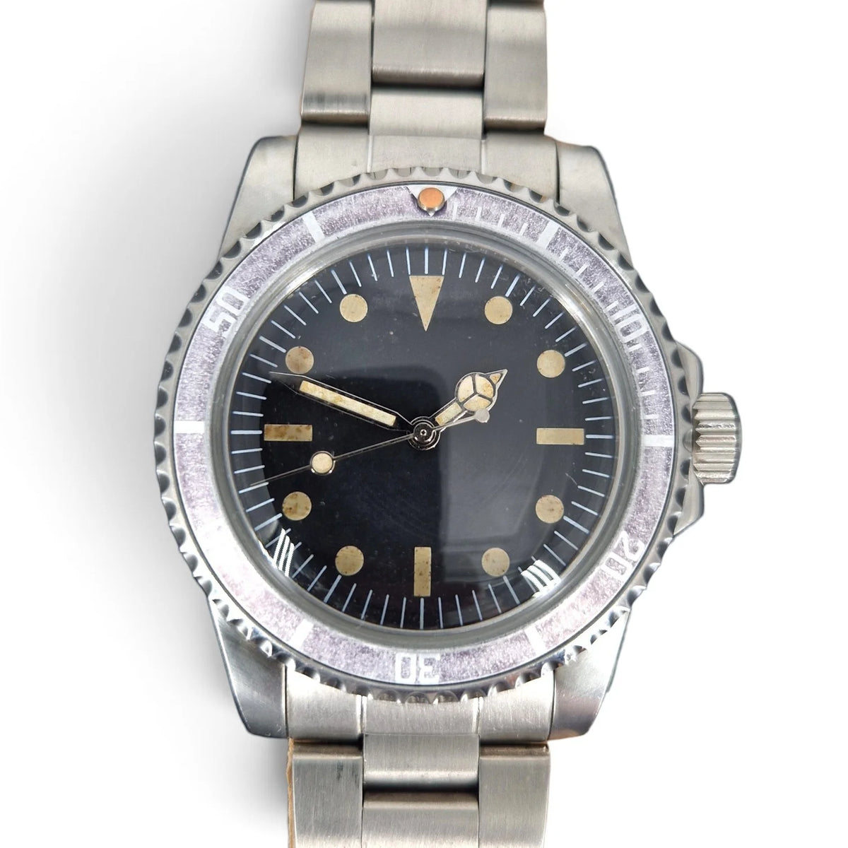 Close-up of the aged black dial, warm vintage lume and faded ghost bezel