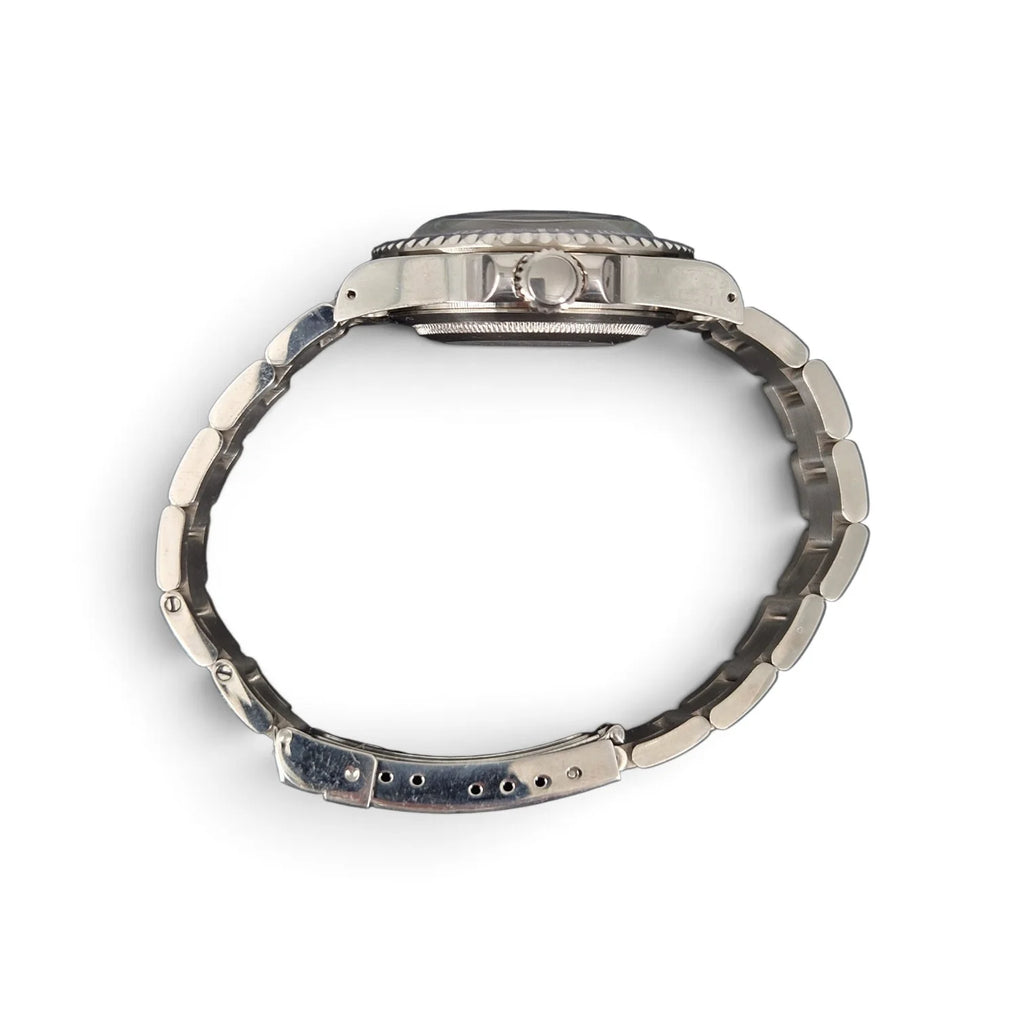 Side profile of the 39.5mm aged ghost-bezel automatic dive watch showing its crown, case thickness and steel bracelet.