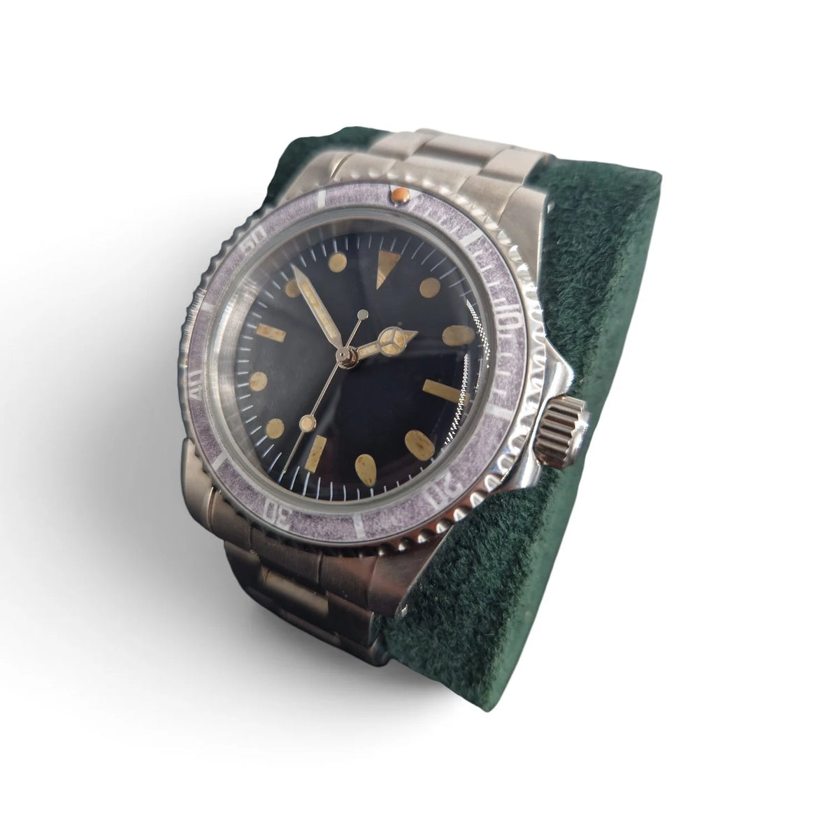 Crown-side view of the aged ghost-bezel automatic dive watch with vintage lume