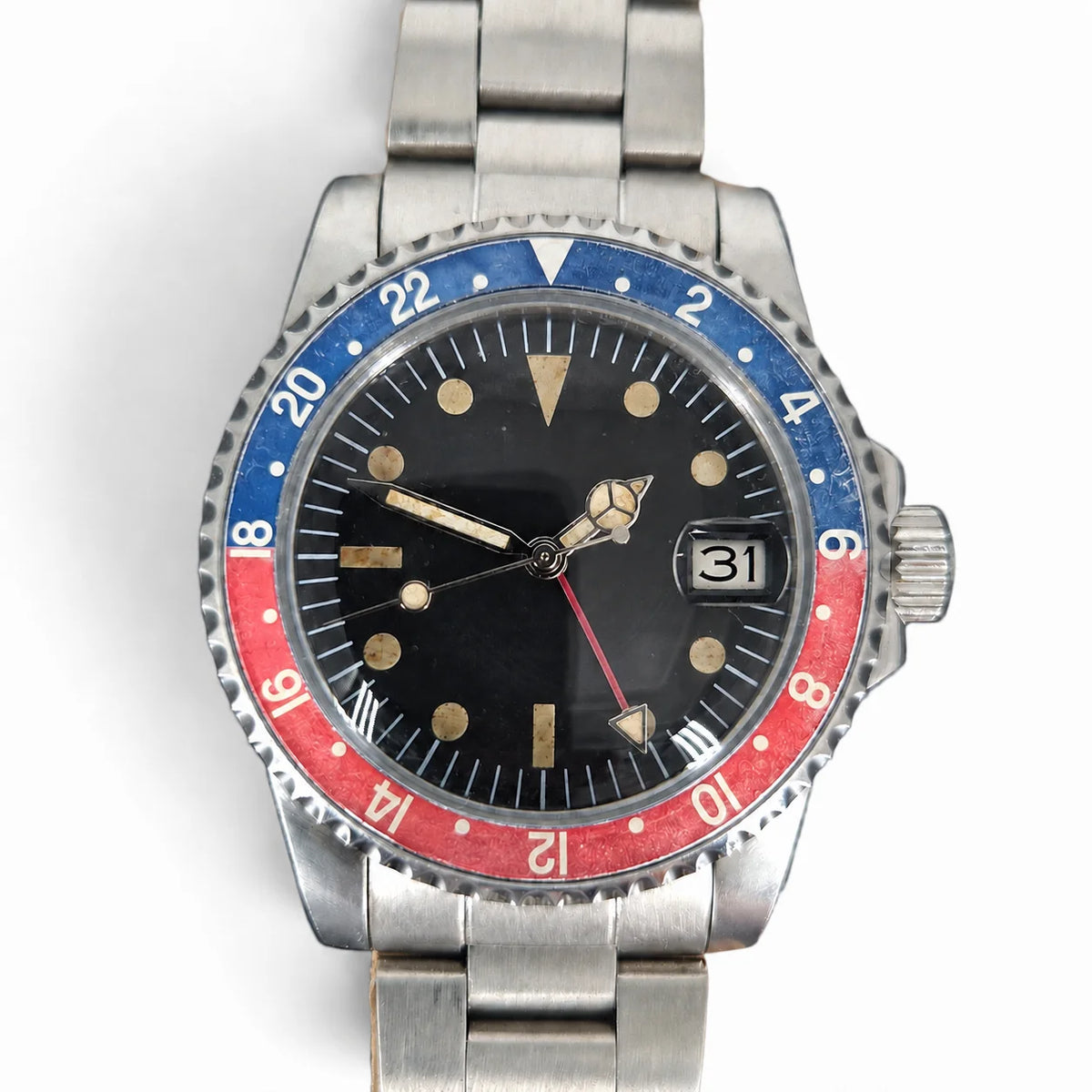 Close-up of the aged red-blue 24-hour bezel, vintage lume, GMT hand and date window