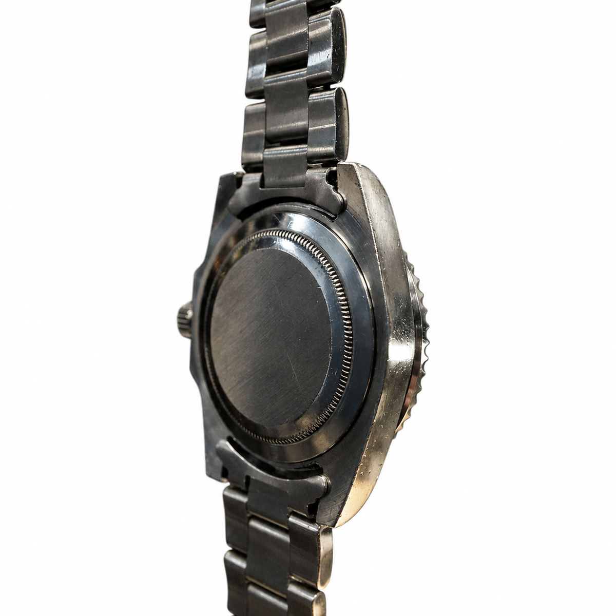 A close-up of a stainless steel wristwatch from the back, showing the brushed metal case back and integrated link bracelet on a white background.