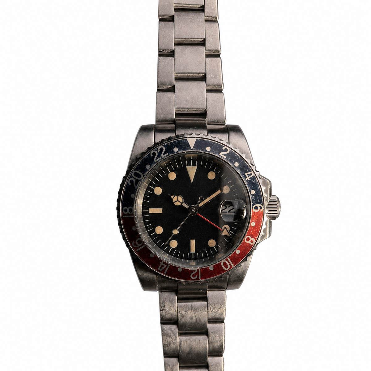 Close-up of a faded black-red aluminum 24-hour bezel and aged matte-black GMT dial