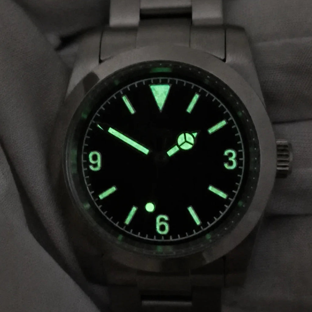 Green lume glowing on the hands, hour markers and 3-6-9 numerals of the automatic field watch