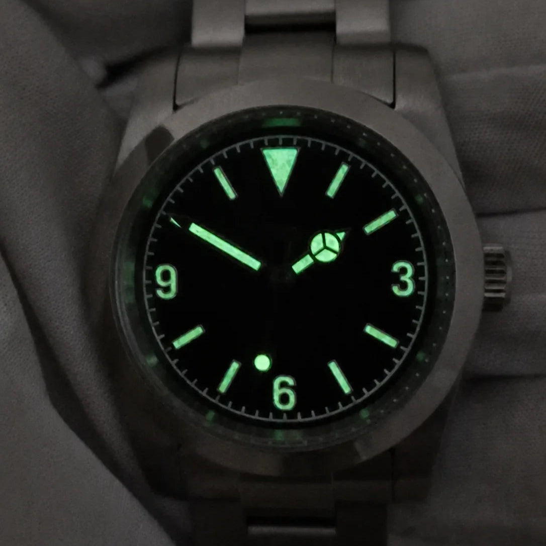 Green lume glowing on the hands, hour markers and 3-6-9 numerals of the automatic field watch