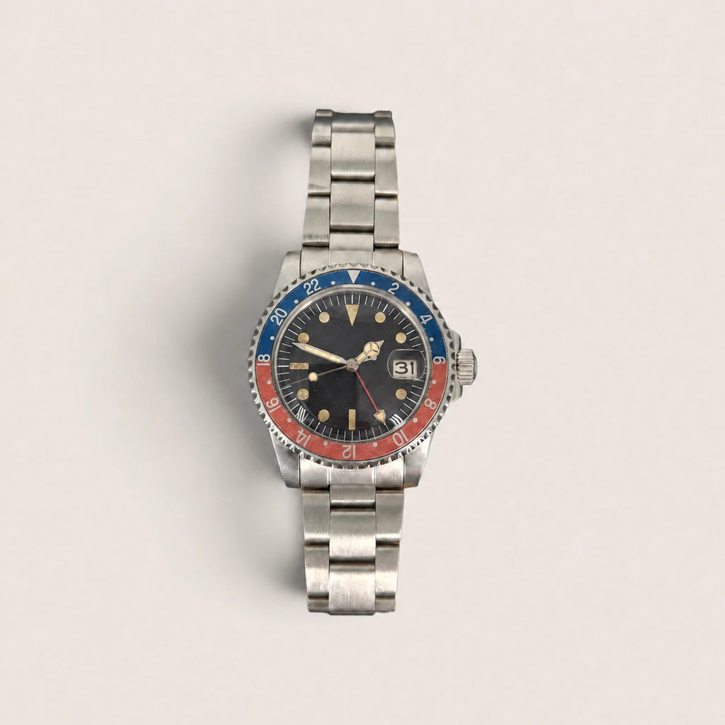 Front view of the vintage red-blue GMT watch with aged bezel, black dial and red GMT hand