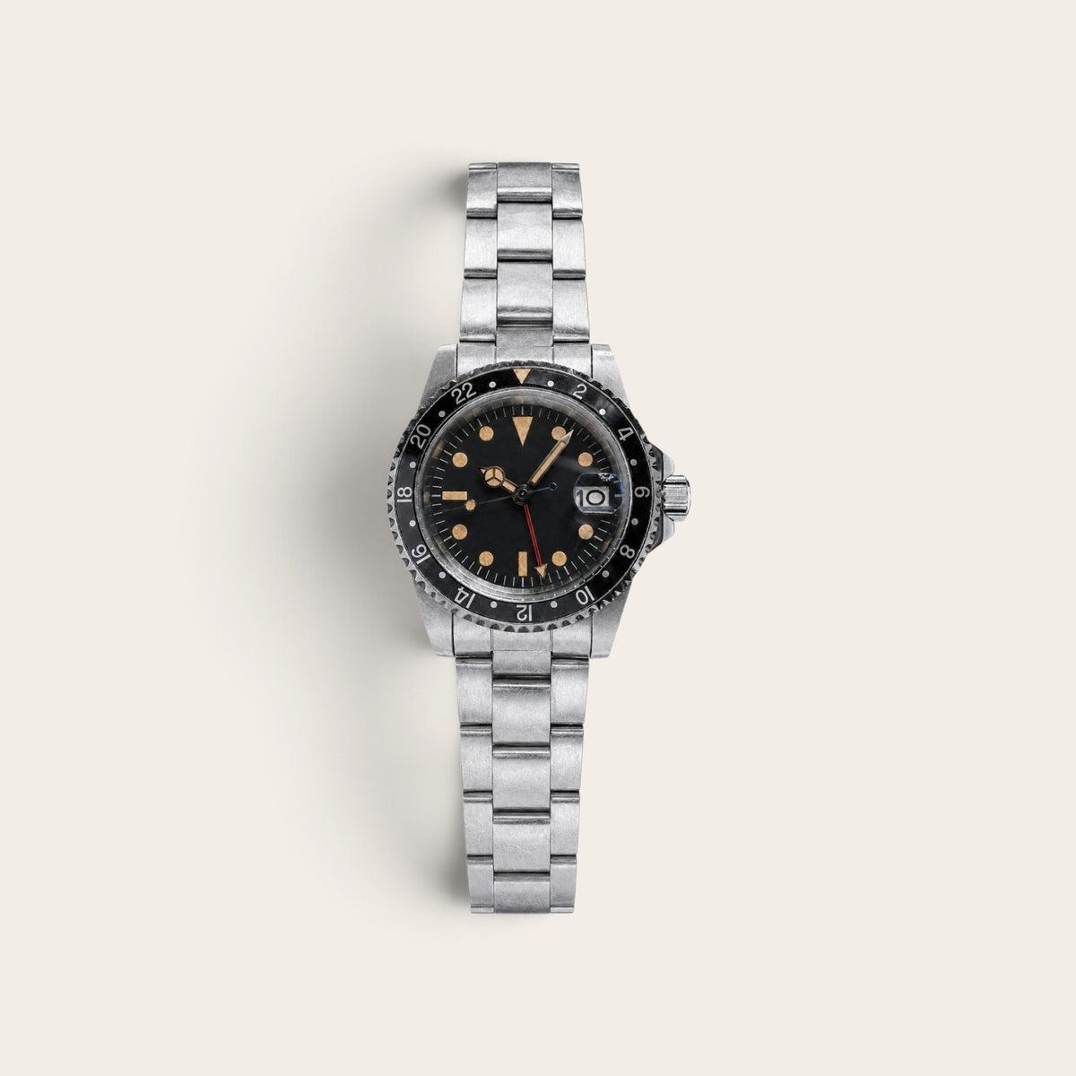 Vintage-style black-bezel GMT watch with a weathered steel case and bracelet